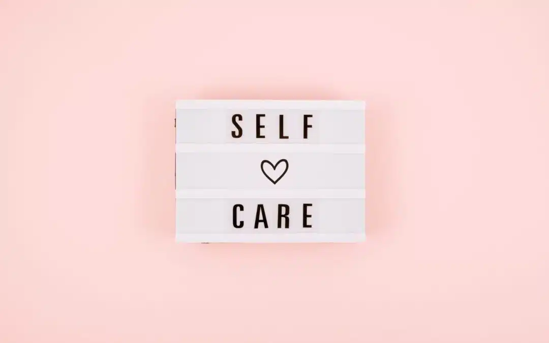 A lightbox with the words "Self Care" and a heart symbol in the middle, set against a pink background.
