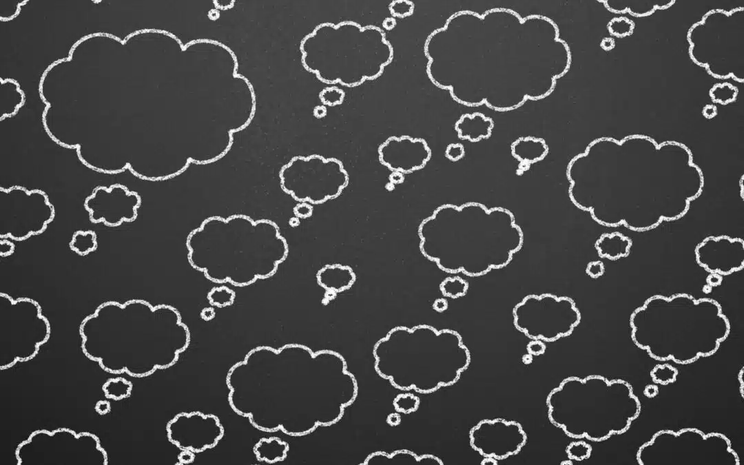 Chalkboard with multiple drawn thought bubbles of varying sizes scattered across a black background.