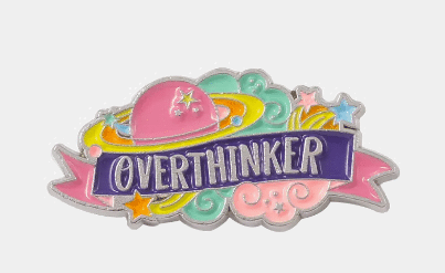 A colorful enamel pin with a pink planet, surrounding clouds, stars, and the word "OVERTHINKER" written in bold letters on a blue banner.